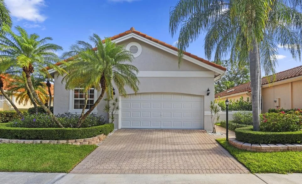 Palm Beach County luxury home framed by palms
